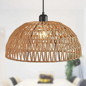 Suspension dôme en corde naturelle beige allumée au-dessus d une table à manger