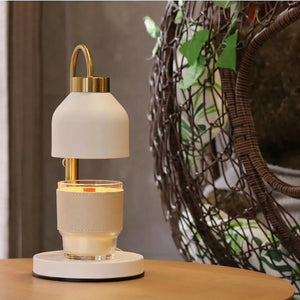 Lampe chauffe-bougie blanche diffusant une lumière chaude dans un intérieur végétalisé