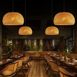 Suspension bambou tressé restaurant quatre lampes allumées lumière ambrée