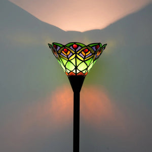 Gros plan de l'abat-jour en vitrail vert du lampadaire Tiffany éclairé, verre coloré détaillé