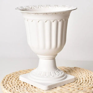 Vase médicis blanc posé sur un set en fibres naturelles