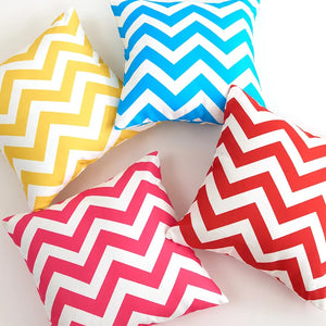 Quatre housses de coussin à chevrons jaune bleu rose et rouge