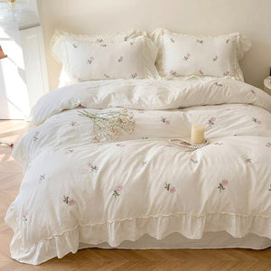 Taies d'oreiller brodées de roses posées côte à côte sur le lit