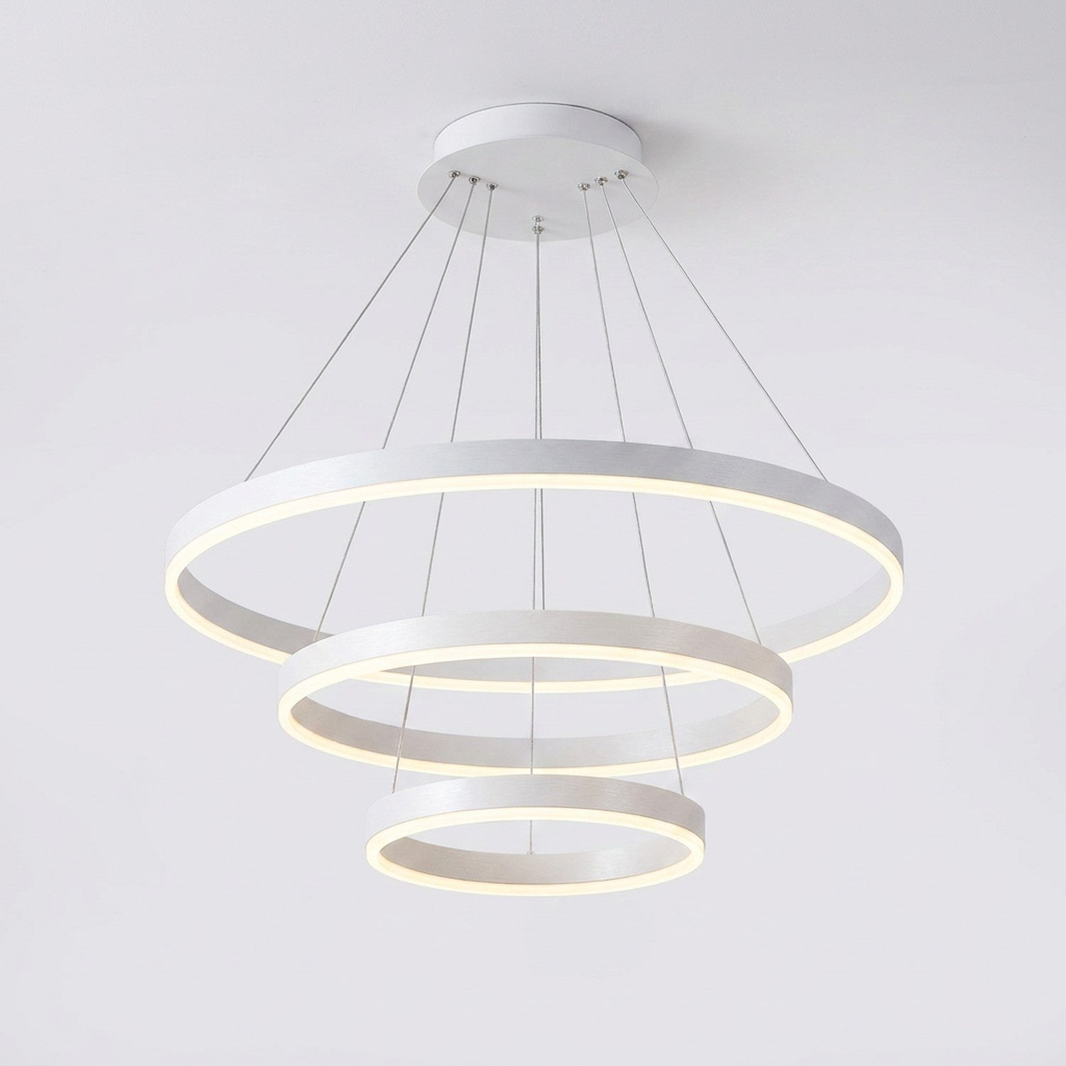 Lustre LED blanc à anneaux concentriques sur fond gris clair, finition blanche