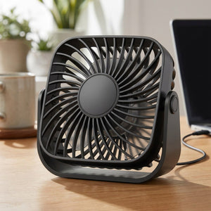 Ventilateur de bureau USB compact noir posé sur un bureau à côté d'un ordinateur portable