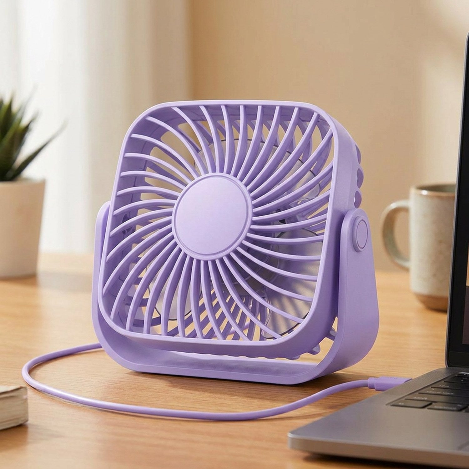 Ventilateur de bureau USB violet posé sur un bureau