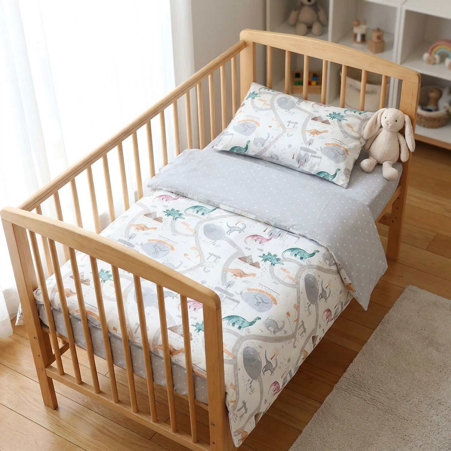Parure de lit bébé dinosaures pastel dans une chambre enfant lumineuse