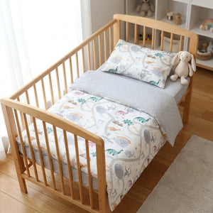 Parure de lit bébé dinosaures pastel dans une chambre enfant lumineuse