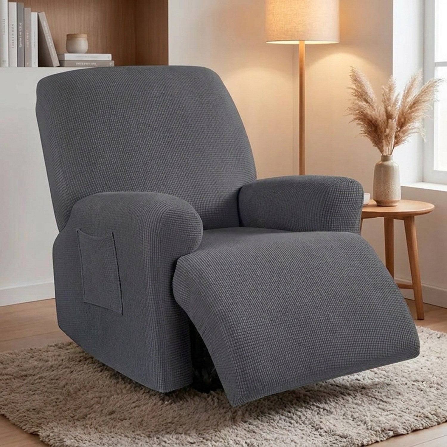 Housse de canapé relax grise sur un fauteuil inclinable une place dans un coin lecture cosy