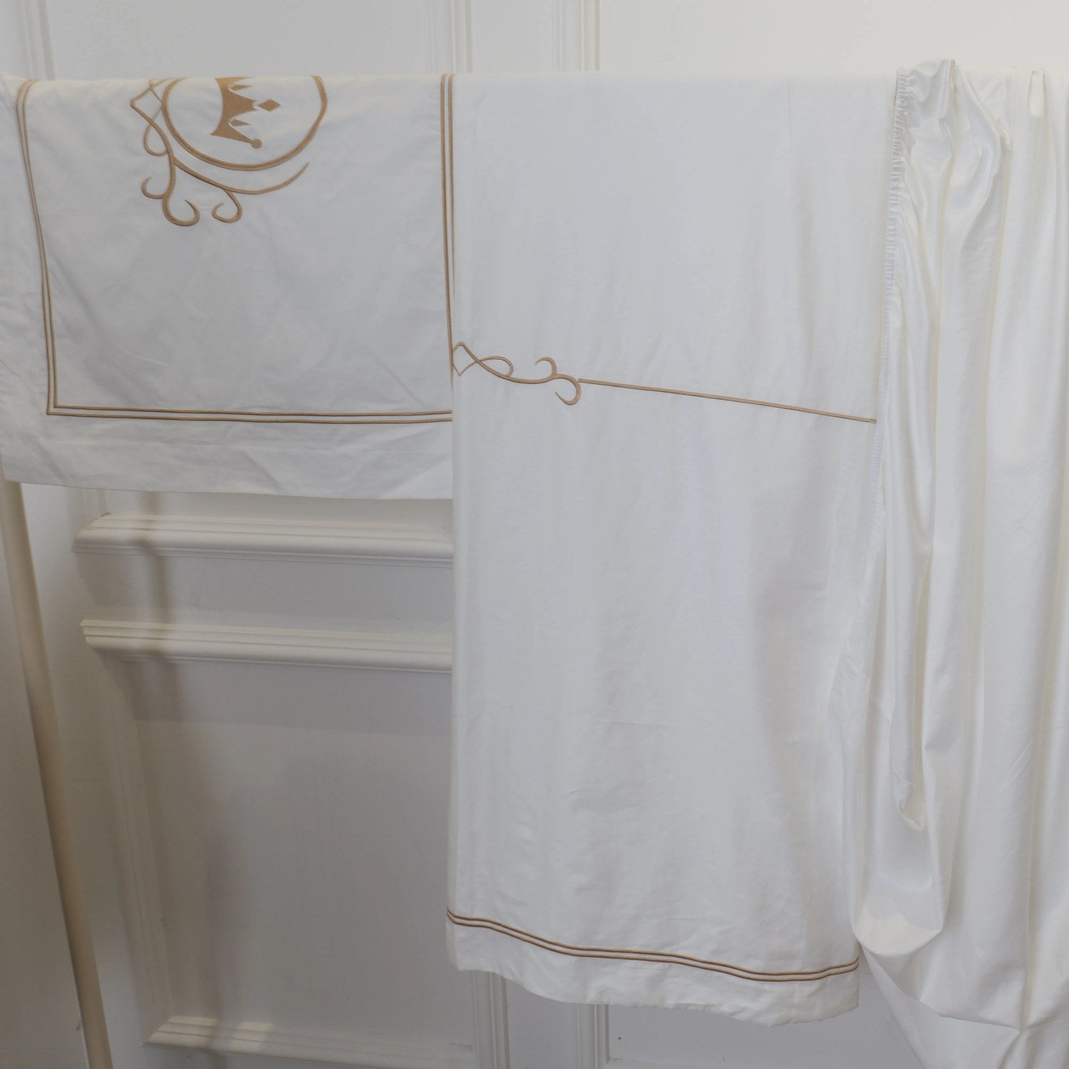 Broderie couronne dorée en gros plan sur la taie de la parure de lit