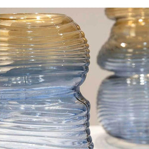 Vase gourde en verre dégradé et vase boule côte à côte sur fond neutre