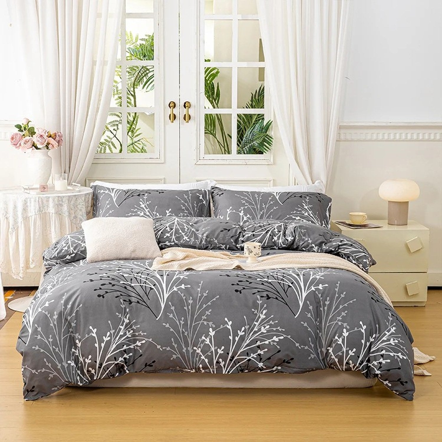Parure de lit fleurie coloris gris sur un lit fait