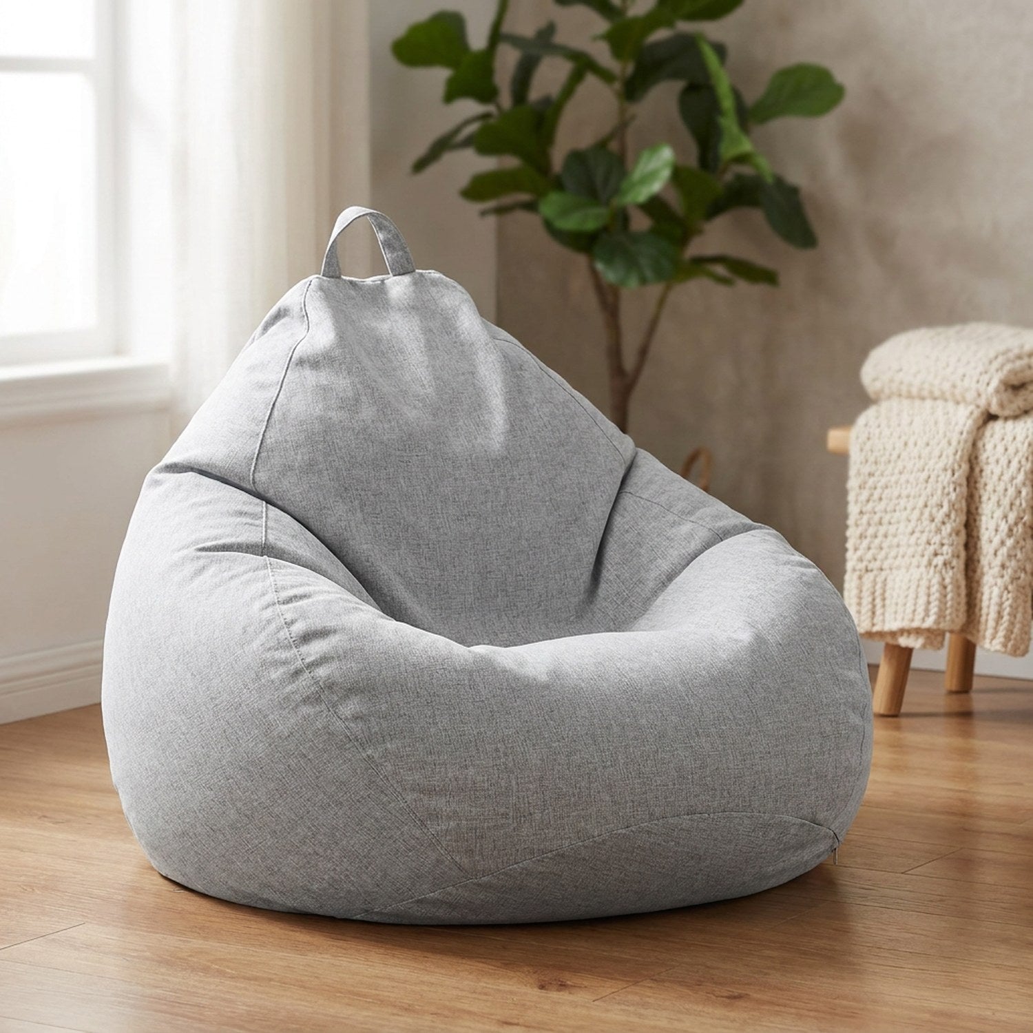 Housse de pouf poire grise en tissu aspect lin posée dans un salon cosy