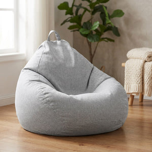 Housse de pouf poire grise en tissu aspect lin posée dans un salon cosy