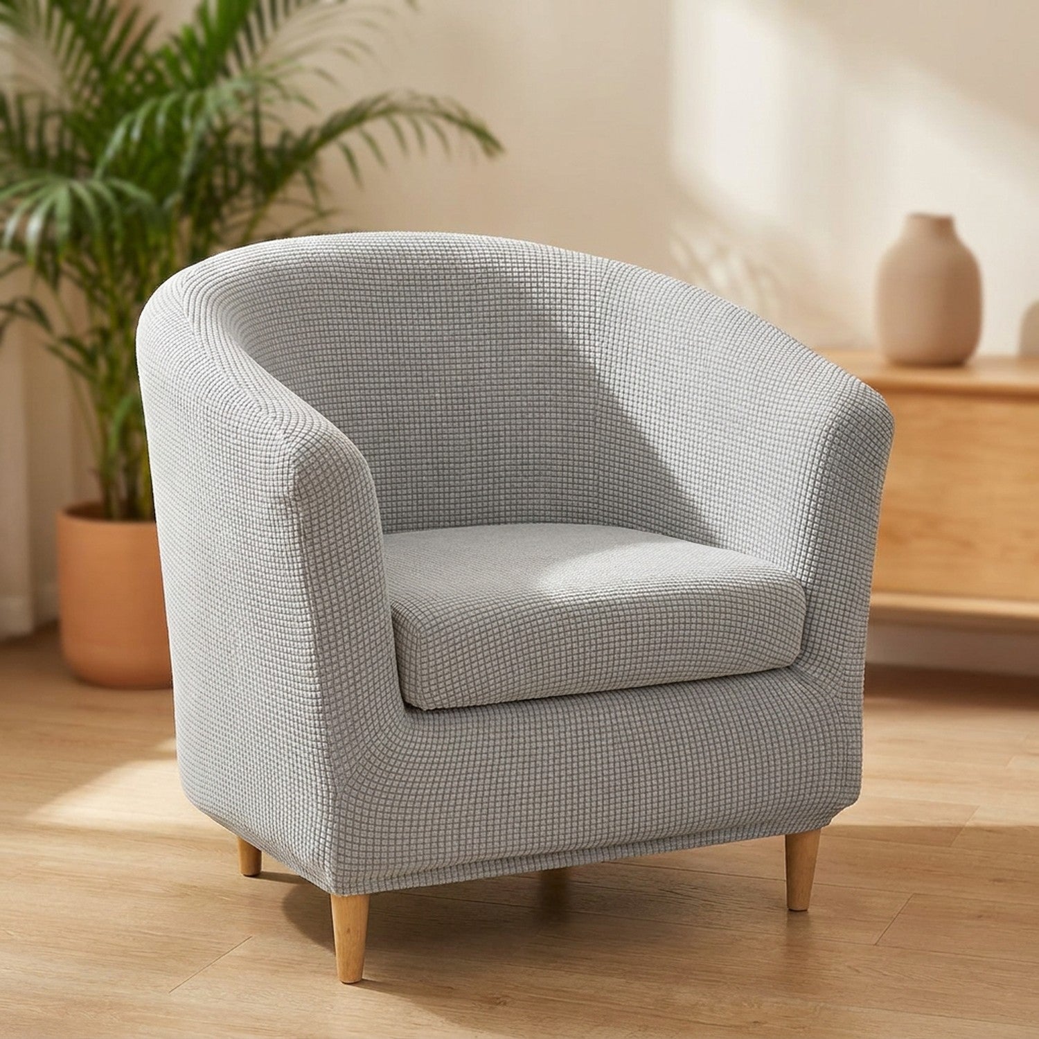 Housse de fauteuil club en jacquard gris clair sur un fauteuil arrondi