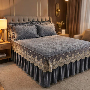 Couvre-lit matelassé en velours gris avec jupe à volants en dentelle sur un lit