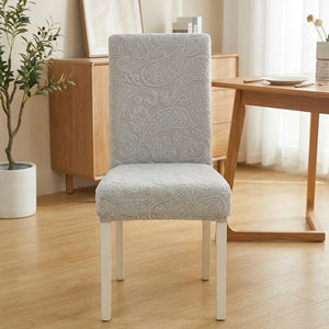 Housse de chaise extensible en jacquard relief gris sur une chaise de salle à manger