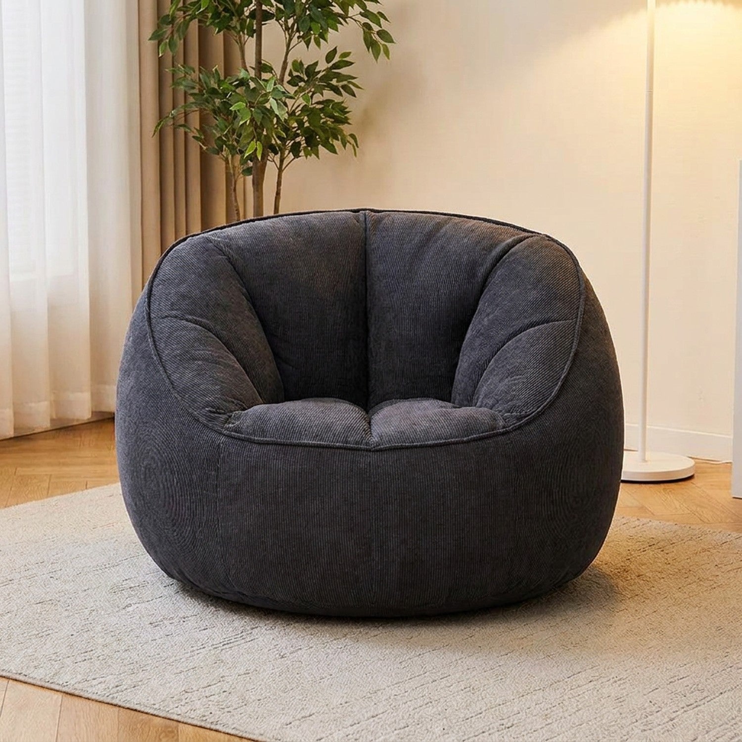 Fauteuil pouf en velours côtelé gris foncé dans un salon moderne