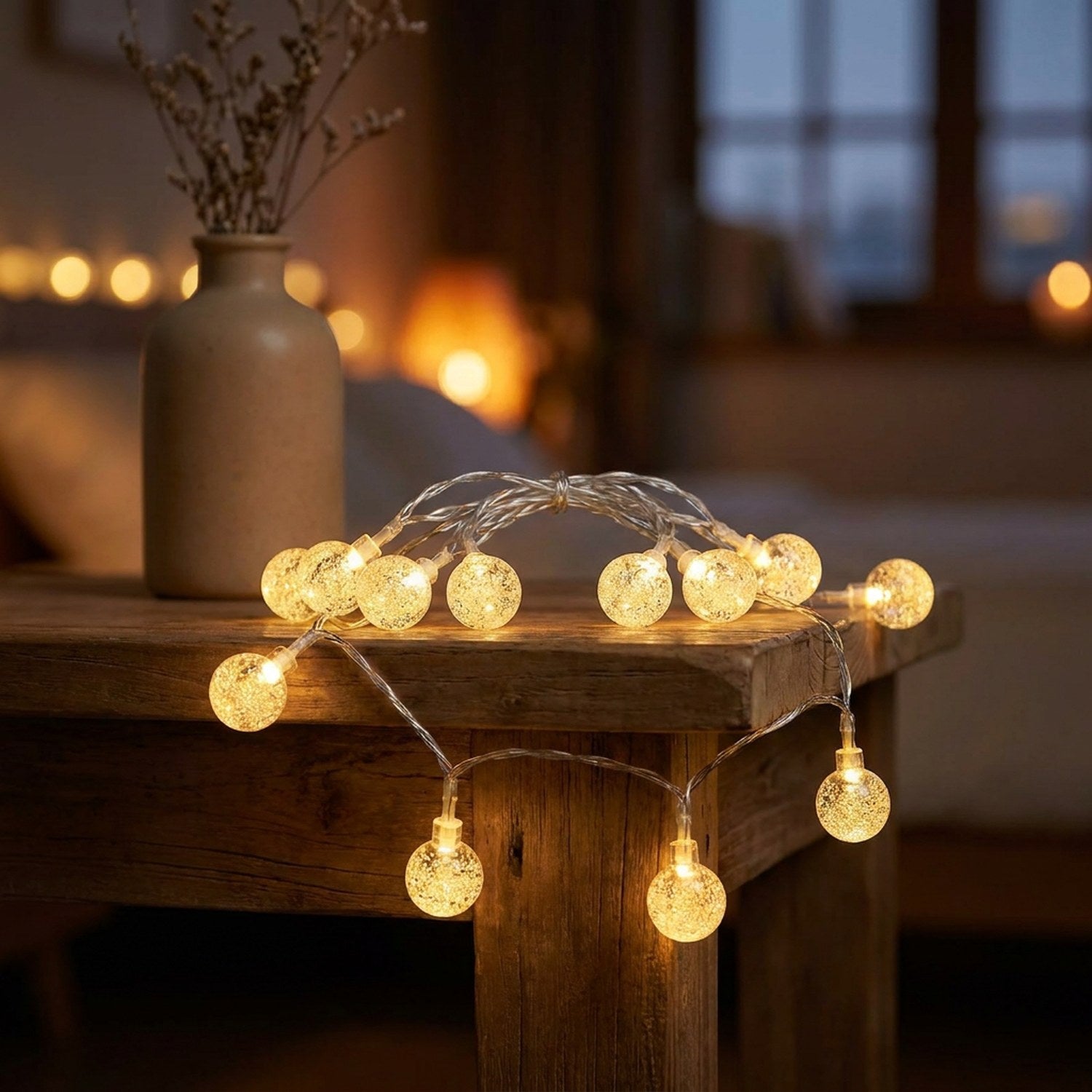 Guirlande lumineuse boule à bulles LED dorée posée sur une table en bois près d un vase et d une cheminée