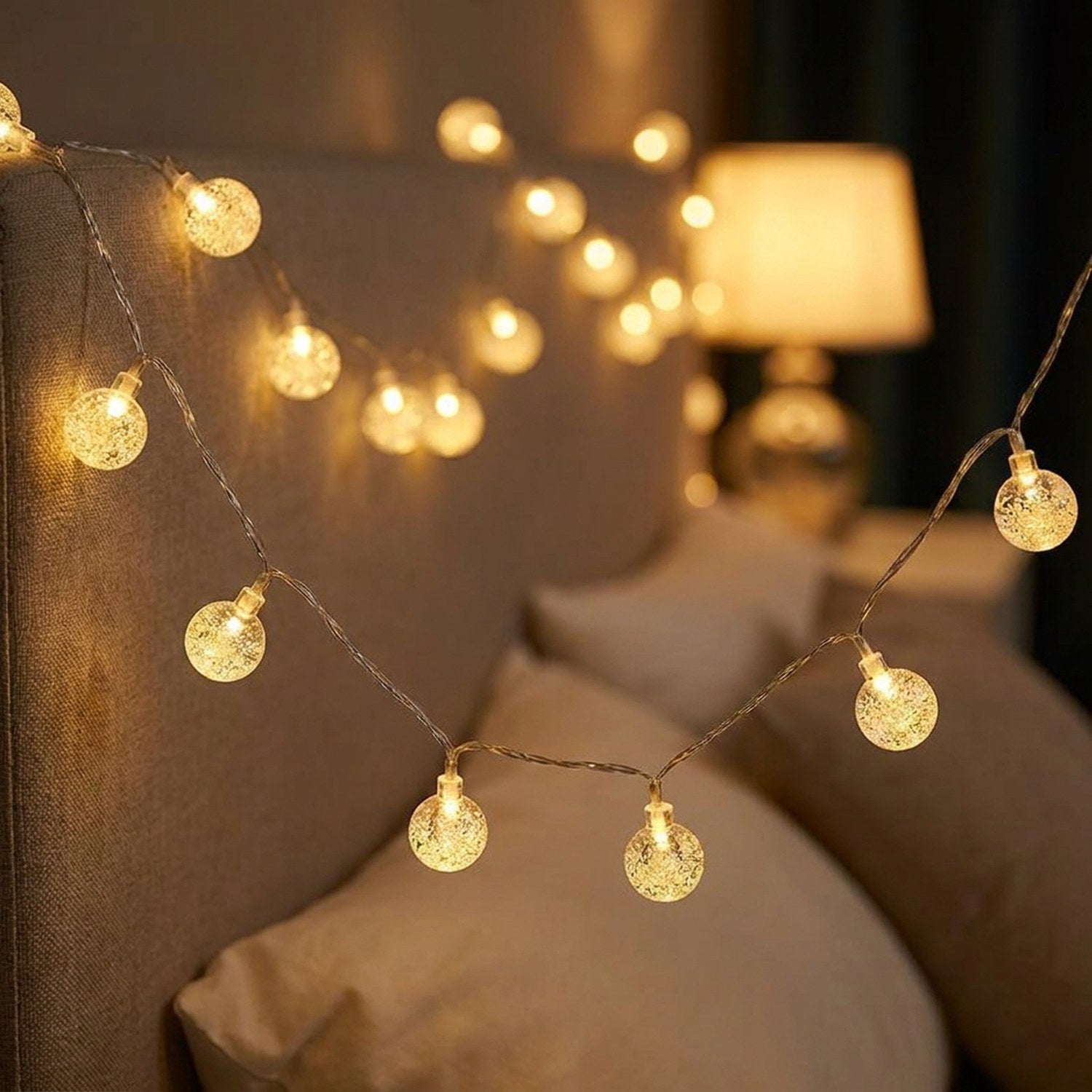 Guirlande lumineuse boule à bulles LED accrochée à la tête de lit dans une chambre cocooning
