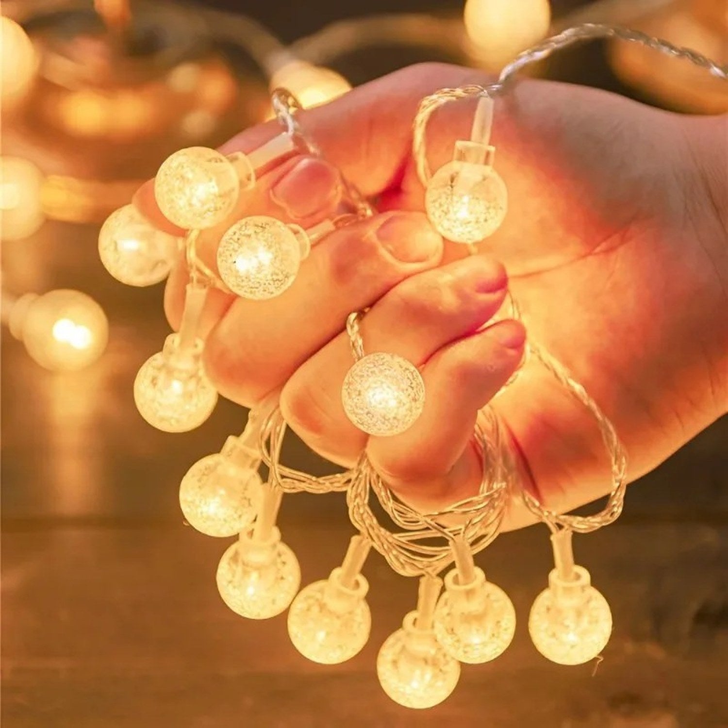 Guirlande lumineuse boule à bulles LED tenue dans une main pour montrer la taille des perles lumineuses