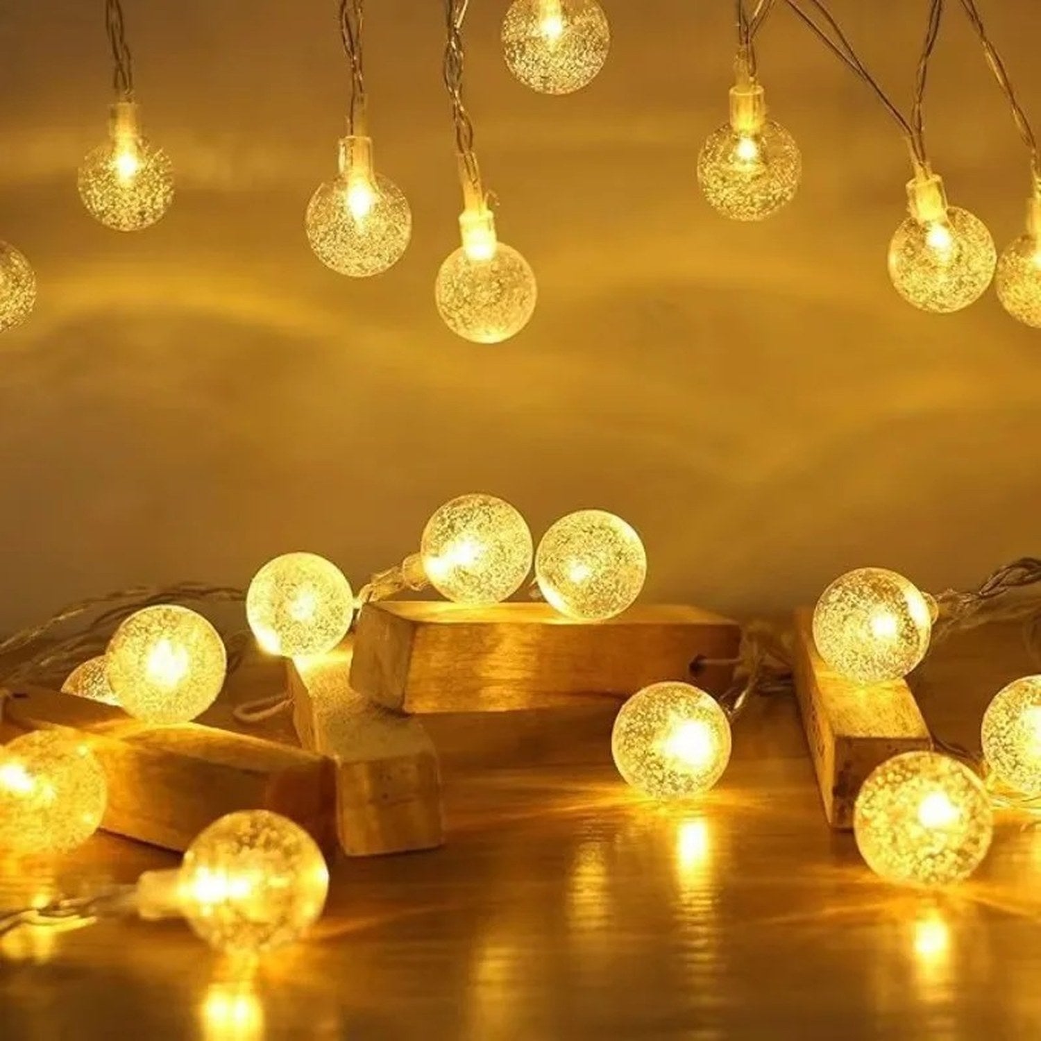 Guirlande lumineuse boule à bulles LED dorée posée sur des blocs de bois