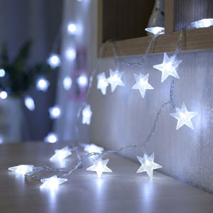 Guirlande lumineuse à étoiles LED blanc froid le long d'un mur cosy
