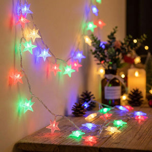 Guirlande lumineuse à étoiles LED multicolores sur une table de fête décorée