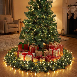 Guirlande lumineuse LED fil vert illuminant la base d'un sapin de Noël avec des cadeaux emballés autour