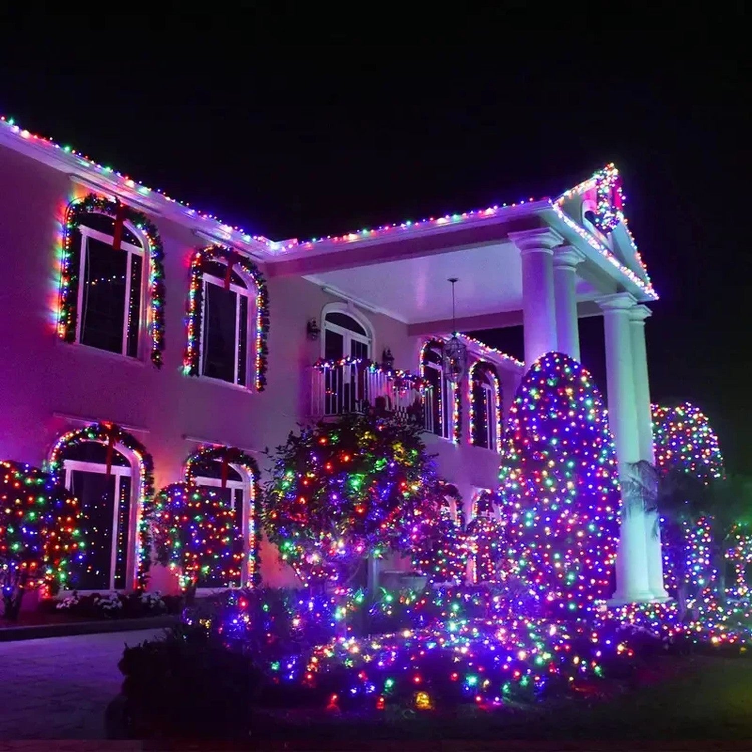 Guirlande LED solaire multicolore illuminant la façade d'une maison en soirée