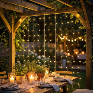 Guirlande lumineuse LED suspendue sous une pergola pour un dîner en extérieur