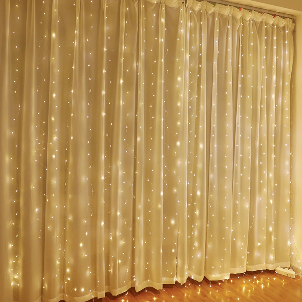Guirlande lumineuse rideau blanc chaud sur rideau beige en chambre
