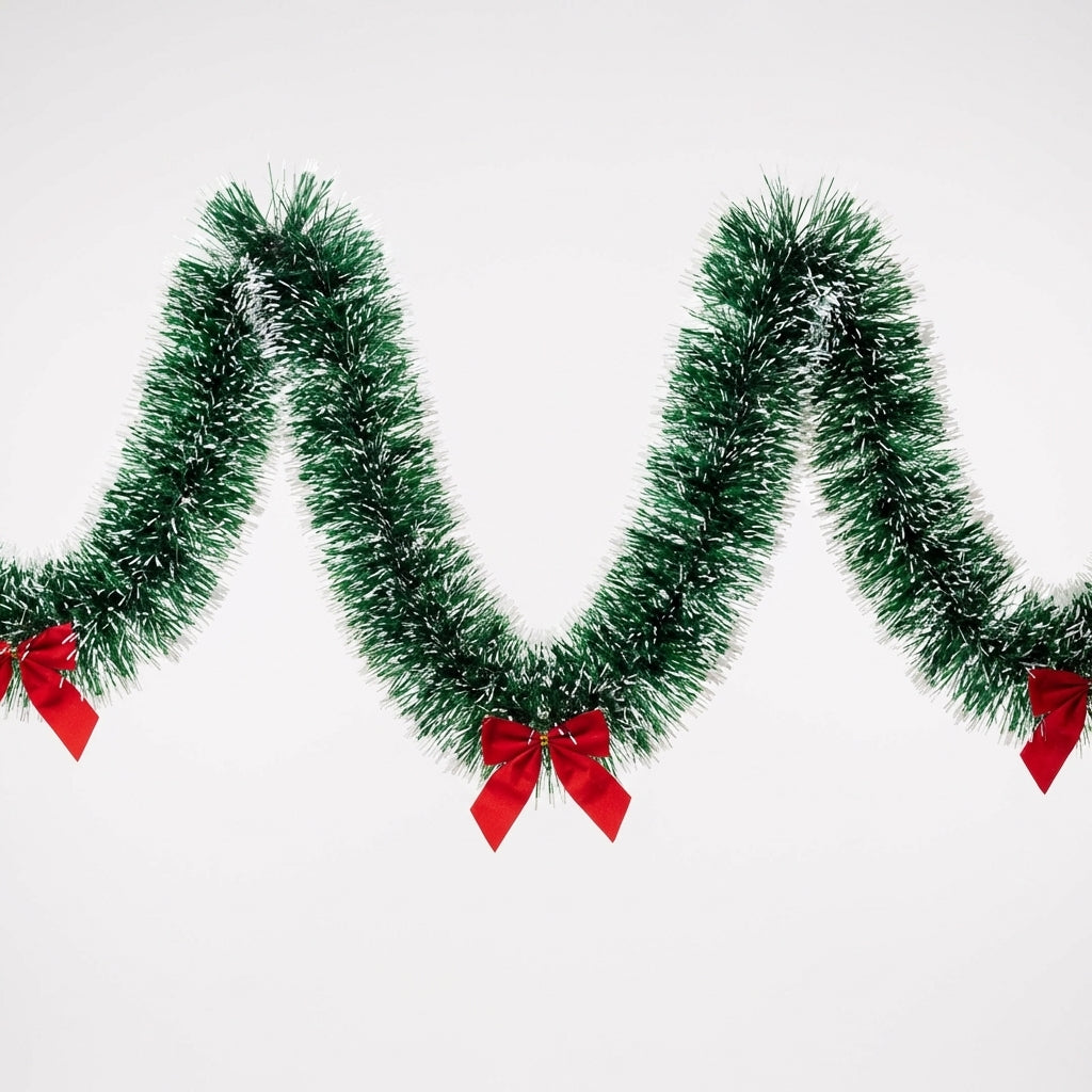 Guirlande de Noël en sapin vert avec nœuds rouges drapée en vagues sur fond blanc