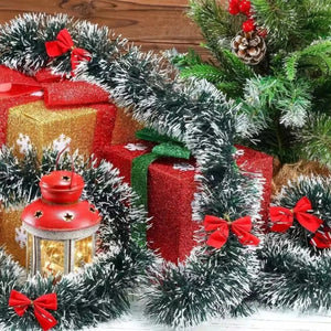 Guirlande tinsel givrée posée parmi des décorations de Noël et cadeaux