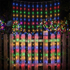 Guirlande rideau LED solaire lumière multicolore arc-en-ciel suspendue sur clôture de jardin la nuit