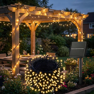 Guirlande lumineuse solaire allumée au-dessus d'une table de jardin sous une pergola