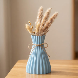 Vase origami plissé bleu clair en plastique avec un nœud en jute et des fleurs séchées
