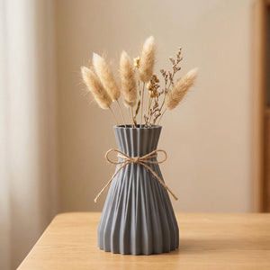 Vase origami plissé gris en plastique avec un nœud en jute et des fleurs séchées