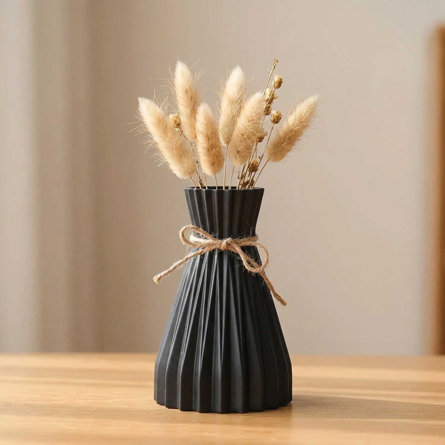 Vase origami plissé noir en plastique avec un nœud en jute et des fleurs séchées