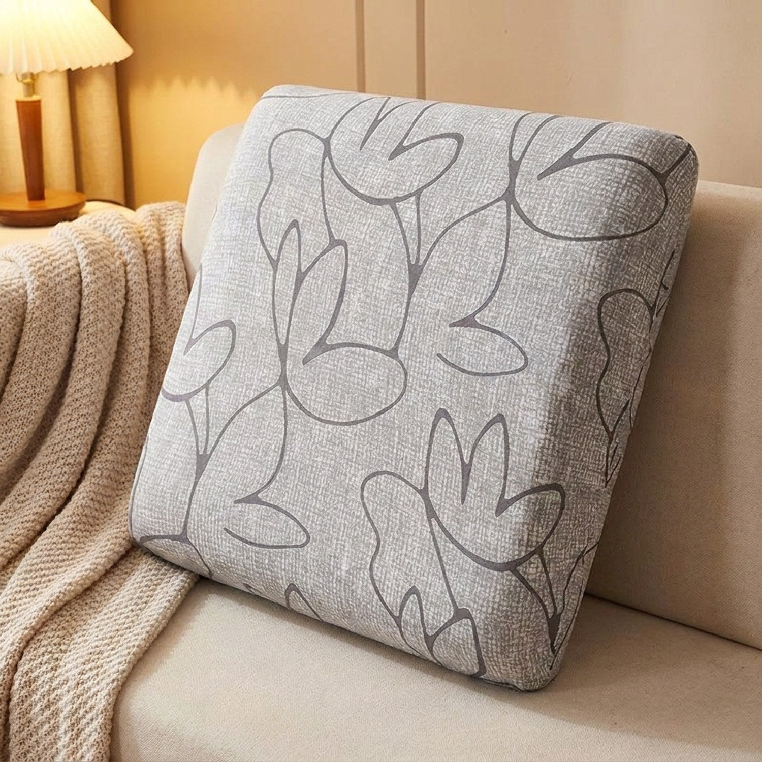 Housse d'assise grise ajustée au plus près sur un coussin de canapé