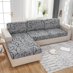 Housse d'assise grise à motif feuillage installée sur les coussins d'un canapé