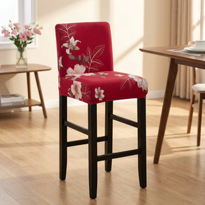 Housse de chaise de bar extensible à motif fleuri rose sur fond rouge dans une salle à manger cosy