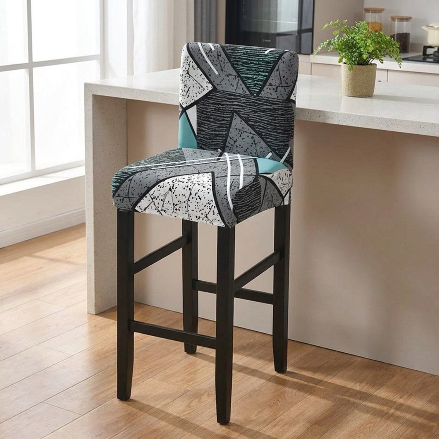 Housse de chaise de bar extensible à motif géométrique gris et turquoise dans une salle à manger lumineuse