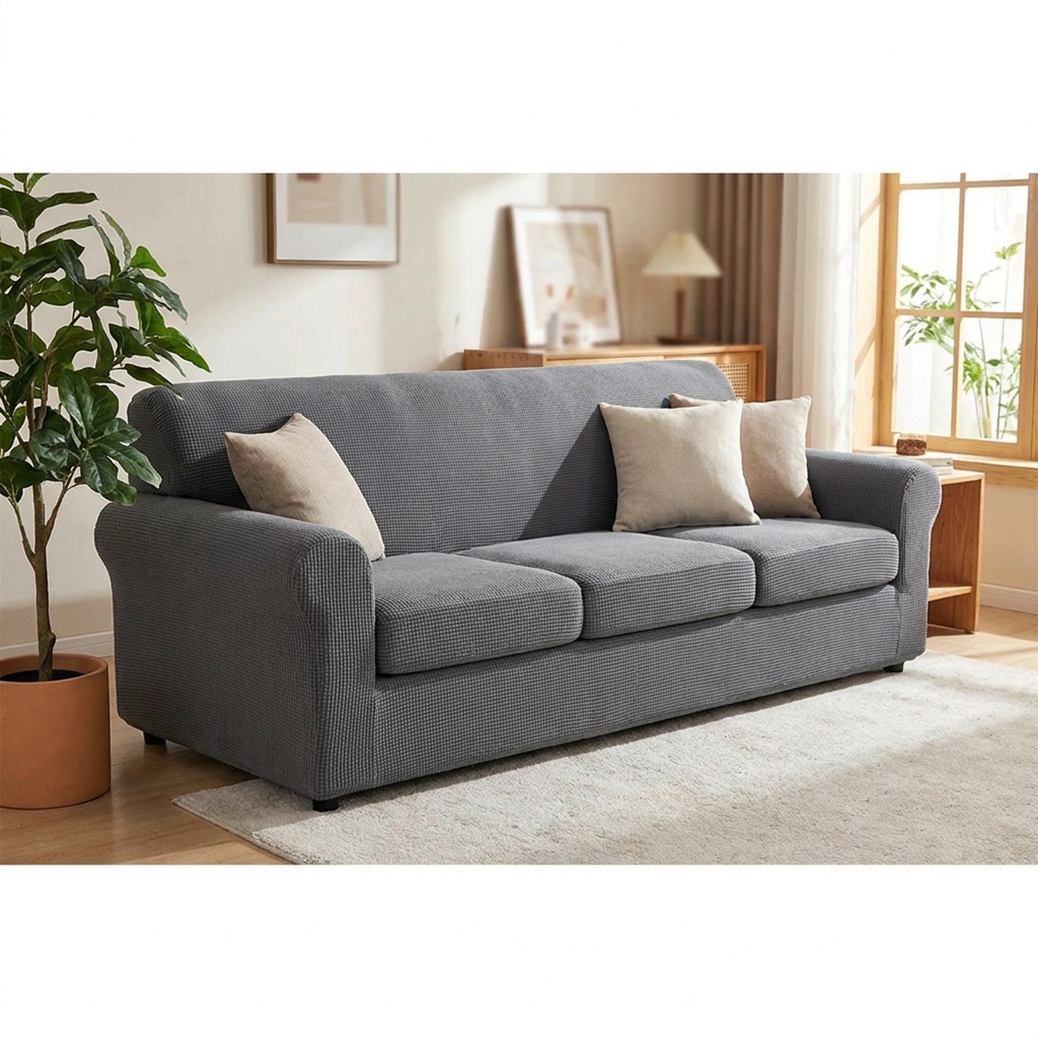 Housse de canapé extensible en jacquard gris installée sur un canapé trois places dans un salon lumineux