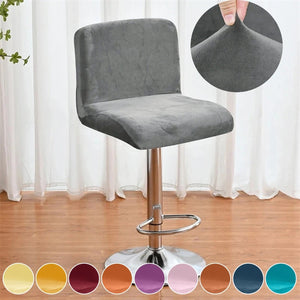 Housse de chaise de bar grise installée sur un tabouret devant un bar