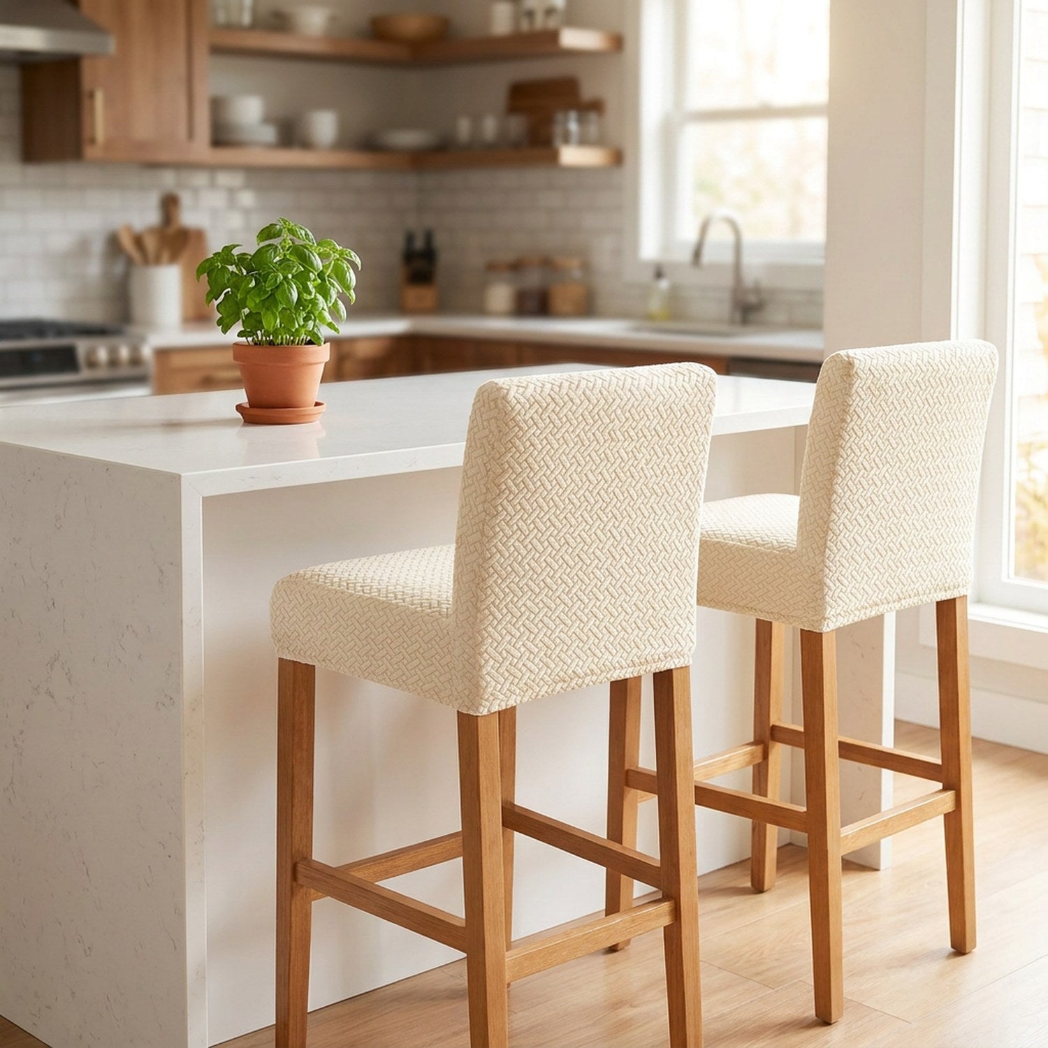 Deux tabourets de bar habillés d'une housse en jacquard beige le long d'un îlot de cuisine moderne