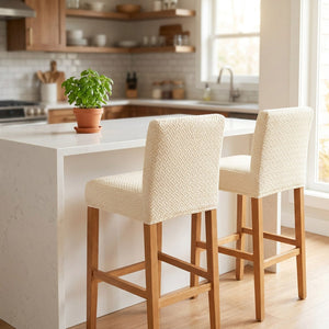 Deux tabourets de bar habillés d'une housse en jacquard beige le long d'un îlot de cuisine moderne