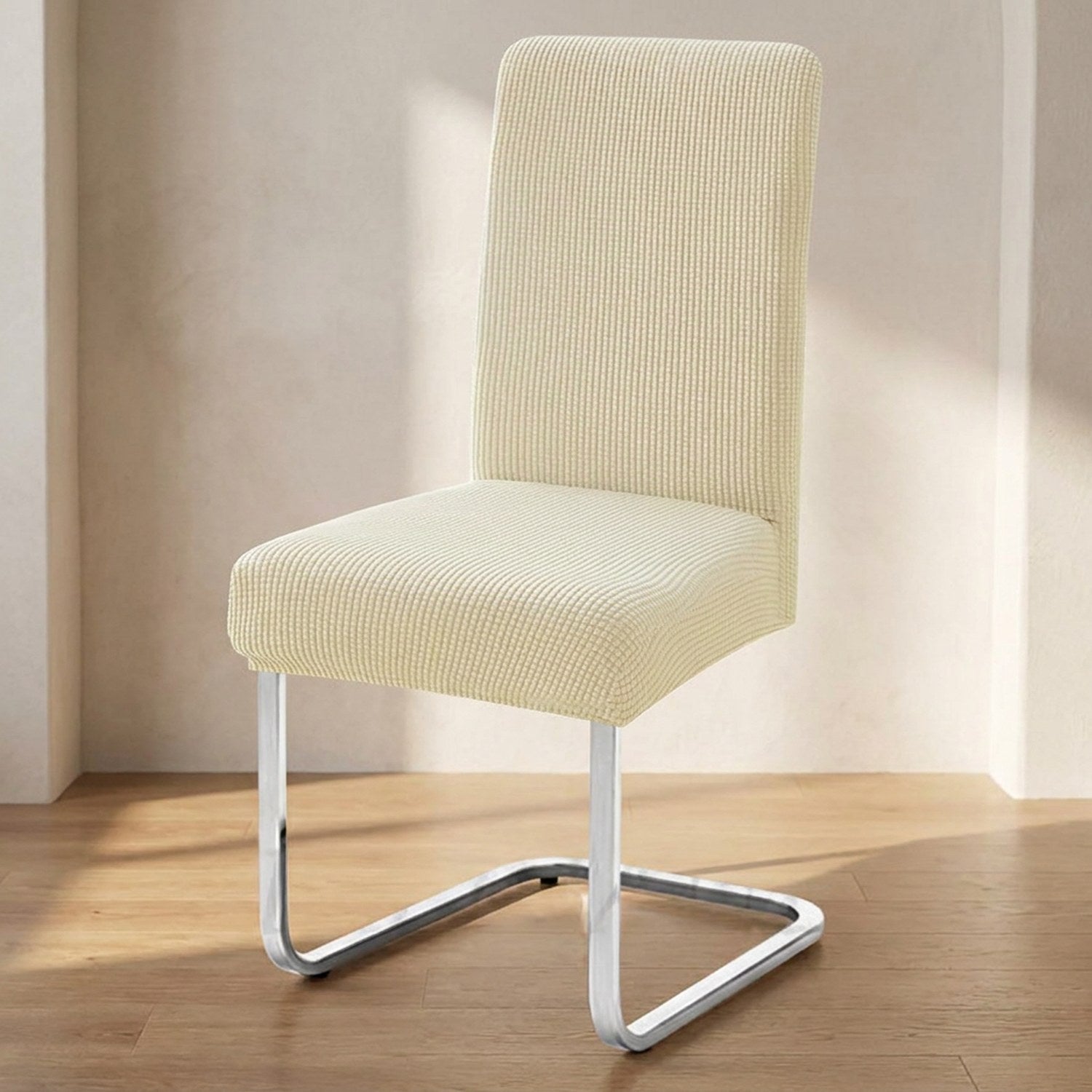 housse de chaise extensible en maille jacquard beige posée sur une chaise dans une salle à manger lumineuse