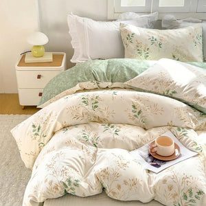 Housse de couette fleurs champêtres posée sur un lit avec taies assorties et coussins blancs