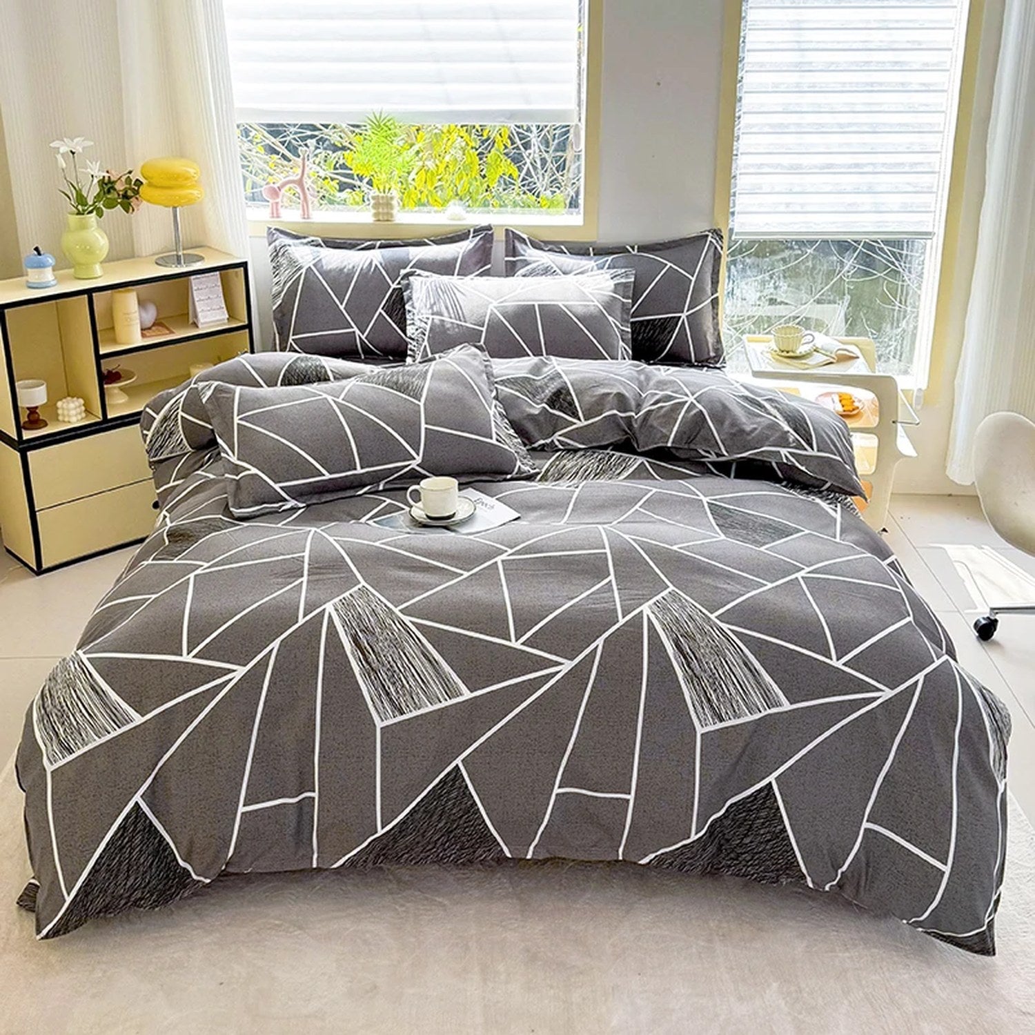 Housse de couette motif géométrique gris et blanc vue complète sur un lit